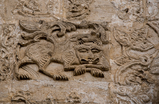  the image of a lion carved in stone.