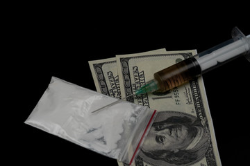 Cocaine or other illegal drugs, white powder, syringe, isolated on black glossy background