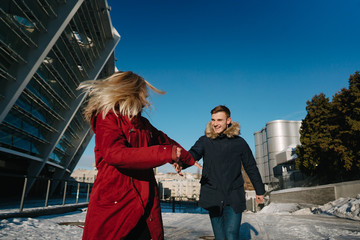 Happy couple walking in the street in winter in a town