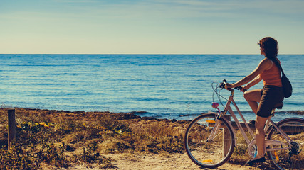 Obraz premium Woman ride bicycle on beach, active lifestyle.