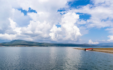 Blue sky, white clouds, calm sea and beach.
