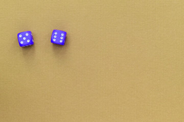 Blue dice on a yellow paper surface. Gambling background. Top view, copy space