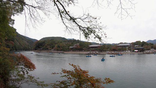 Tourists explore historic Katsura River by rowboat in Arashiyama Kyoto