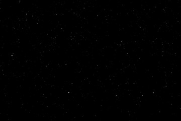 WHITE BOKEH ON A BLACK BACKGROUND. LIGHT SPOTS TEXTURE. FALLING SNOW. STAR SKY.