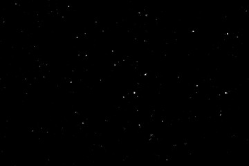 WHITE BOKEH ON A BLACK BACKGROUND. LIGHT SPOTS TEXTURE. FALLING SNOW. STAR SKY.