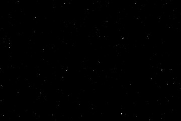 WHITE BOKEH ON A BLACK BACKGROUND. LIGHT SPOTS TEXTURE. FALLING SNOW. STAR SKY.