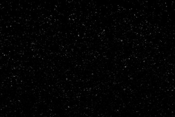 WHITE BOKEH ON A BLACK BACKGROUND. LIGHT SPOTS TEXTURE. FALLING SNOW. STAR SKY.