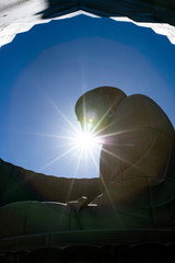 Obraz premium buddha statue and sun ray against clear blue sky