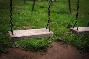 empty children's swing on the background of grass