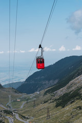 Aerial railway with cable car at peaceful green highland