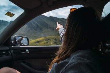 Faceless female tourist pointing toward upland area