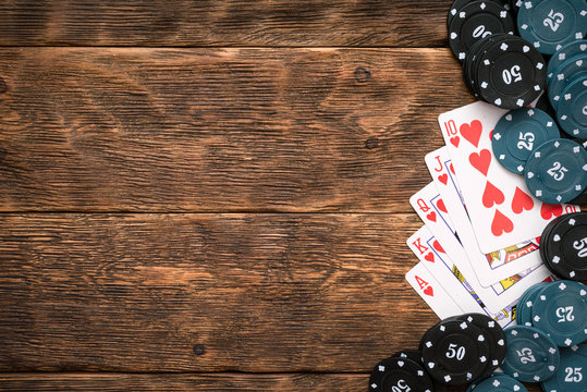 Royal Flush cards and poker chips on green flat lay background.