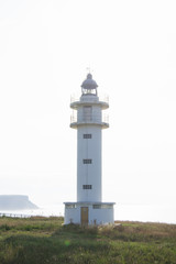White beacon on coastline in daytime