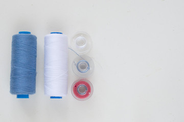 Sewing accessories on a light background close-up. Multi-colored spools of thread