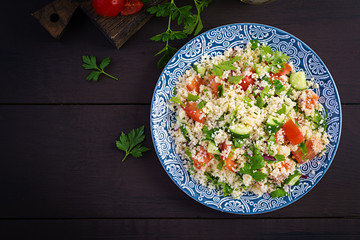 Traditional Lebanese Salad Tabbouleh. Couscous with parsley, tomato, cucumber, lemon and olive oil. Middle Eastern cuisine. Top view, copy space