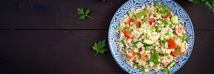 Traditional Lebanese Salad Tabbouleh. Couscous with parsley, tomato, cucumber, lemon and olive oil. Middle Eastern cuisine. Top view, banner
