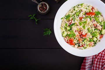 Traditional Lebanese Salad Tabbouleh. Couscous with parsley, tomato, cucumber, lemon and olive oil. Middle Eastern cuisine. Top view, copy space