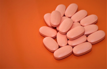 Obraz na płótnie Canvas vitamin pills on orange background