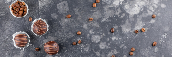 Chocolate truffle, coffee beans on a dark background. Handcrafted chocolate candy. Top view. Banner.