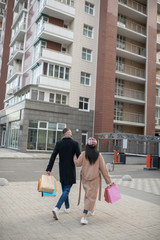 Nice stylish couple returning from the shopping mall