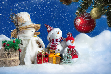 Snowman in a snowdrift with gifts for Christmas and New year