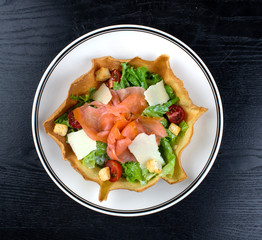 vegetable salad topped with smoked salmon and cheese