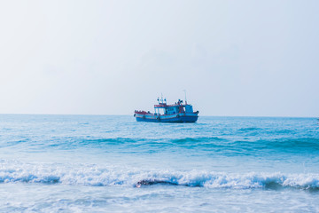 A fishing boat floating in the sea in the blue sea.
