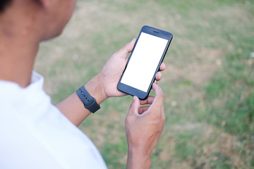 Mockup smartphone of man’s holding black mobile phone with white screen in his office.