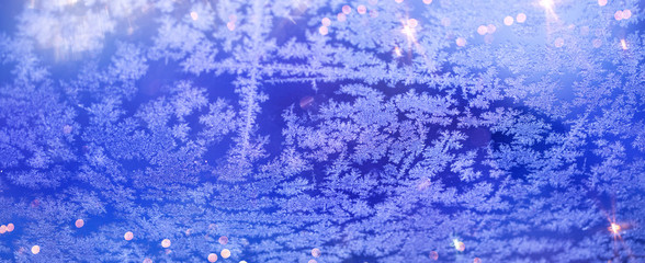 Christmas and New Year holidays background with frost patterns. Glitter lights backdrop. Winter season. Text space.