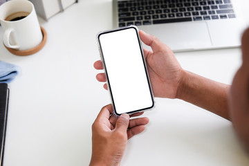 Mockup smartphone of man’s holding black mobile phone with white screen in his office.