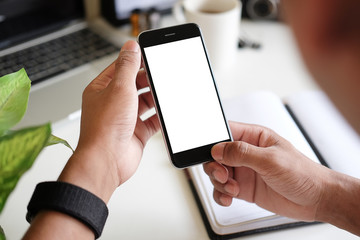 Mockup smartphone of man’s holding black mobile phone with white screen in his office.