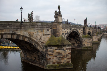 Fototapeta premium The oldest bridge in Prague Charles Bridge at dawn on the eve of the Christmas holidays with virtually no tourists.