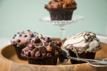 Muffin Auswahl mit Blaubeeren, Walnuss, Haselnuss und Weiße Schokolade mit Milch und Zucker für Kaffeepause auf Marmor Tisch und Grün Hintergrund