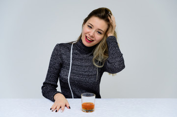 Portrait of a sitting woman at the table talking with curly hair with emotions in a gray dress on a...