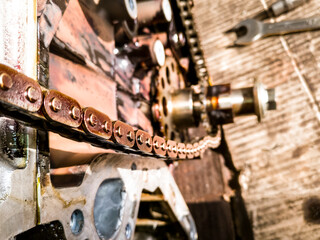 closeup of oily rusty chain of an opened a vehicle engine during repair