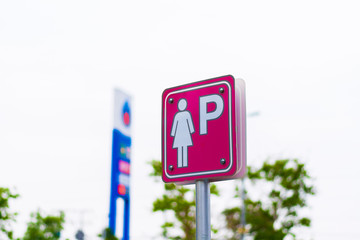 Parking signs for women. That has a pink sign and is attached to the gas station.