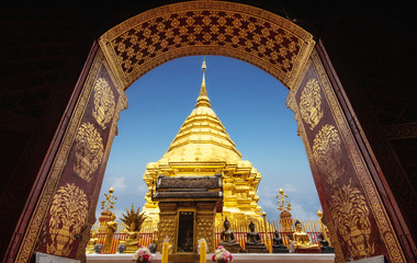 golden pagoda view through from ancient door architrave arch at Wat Phra That Doi Suthep temple. popular famous tourist temple attraction landmark in Chiangmai, Thailand - obrazy, fototapety, plakaty
