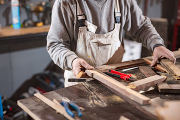 Carpenter working on a old wood in a retro vintage workshop.