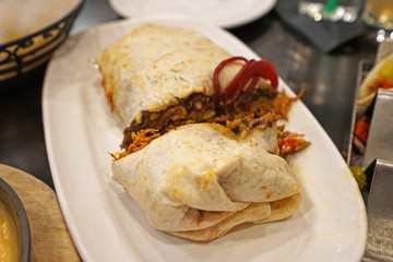 Chicken burrito ,Mexican and Tex-Mex cuisine consists of a flour tortilla with various other ingredients wrapped into a closed-ended cylinder shaped