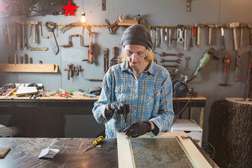 Carpenter working on the old wood in a retro vintage workshop.