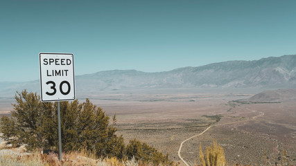 Speed limit sign on road in desert	