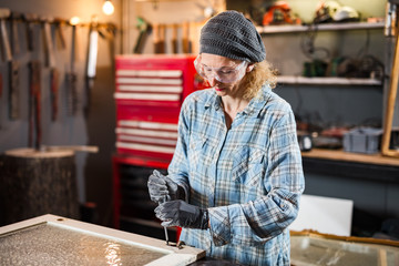 Carpenter working on the old wood in a retro vintage workshop.