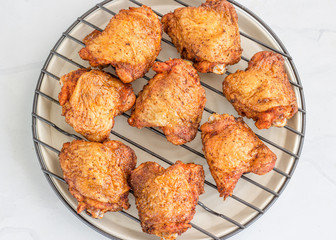 Crispy Oven Fried Chicken Thighs on a grill Rack on White Background, Top View Food Photography..