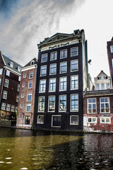Obraz premium Typical buildings, canal and bikes in Amsterdam, Netherlands