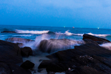 The rocks on the beach and the incoming sea water. And the sea and sky background