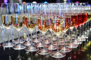 Rows of full champagne, sparkling wine and red wine glasses. Dining, drink. Catering service concept.