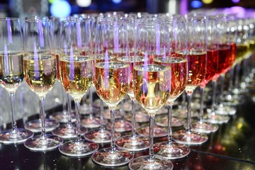 Rows of full champagne, sparkling wine and red wine glasses. Dining, drink. Catering service concept.