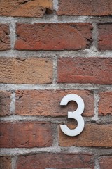 number 3 on brick wall
