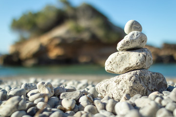 Torre de piedras en equilibrio en la playa con fondo desenfocado