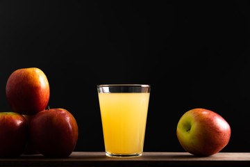 Group of fresh apple on rustic wood table and juice on black background